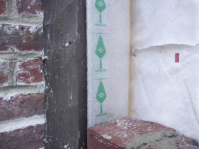 Green spacing tape applied to a brick corner post